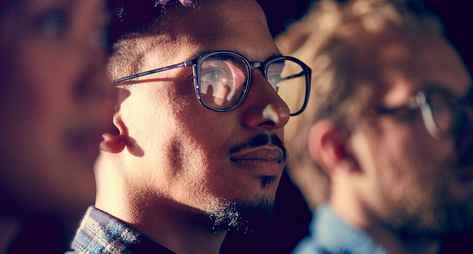 A young mixed race male employee watches a presentation