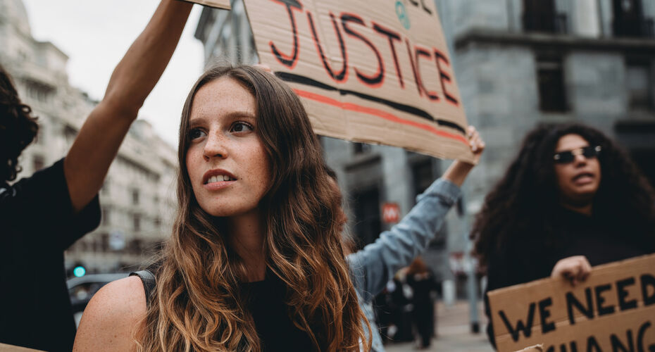 woman at a protest with justice banner